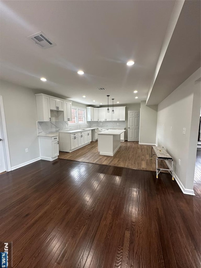 unfurnished living room featuring dark wood finished floors, visible vents, recessed lighting, and baseboards