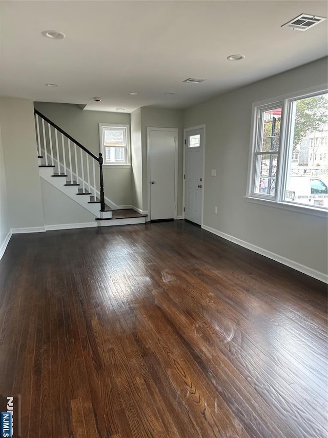 entryway featuring stairway, baseboards, visible vents, and dark wood-style floors