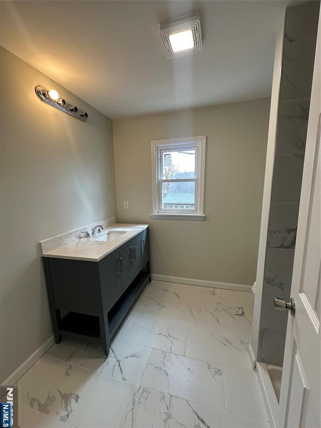 bathroom featuring vanity, baseboards, and marble finish floor