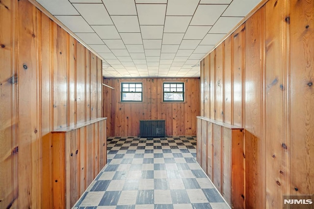 interior space with tile patterned floors and wood walls