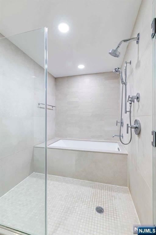 bathroom with a shower stall and a tub to relax in