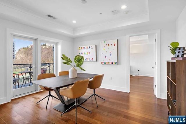 dining area with wood finished floors, visible vents, baseboards, recessed lighting, and a raised ceiling