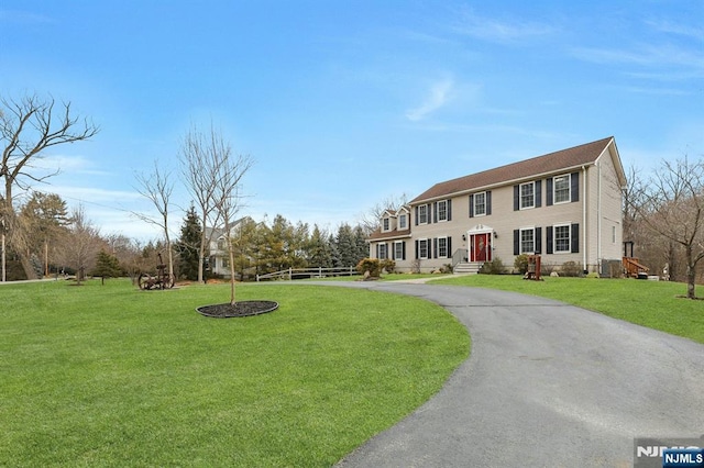 view of front of property featuring aphalt driveway and a front lawn