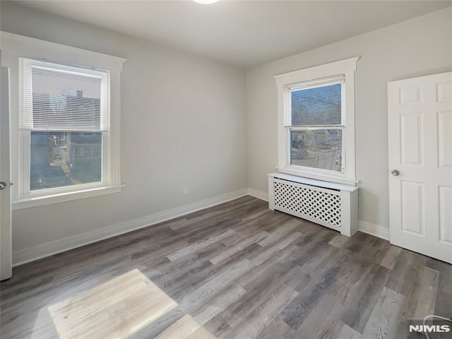 empty room with wood finished floors and baseboards