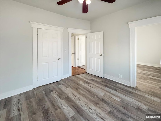 unfurnished bedroom with a ceiling fan, baseboards, and wood finished floors