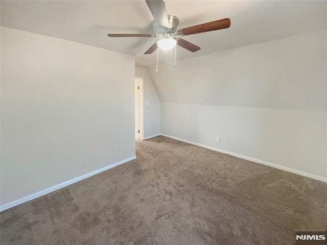 additional living space with baseboards, carpet, lofted ceiling, and ceiling fan