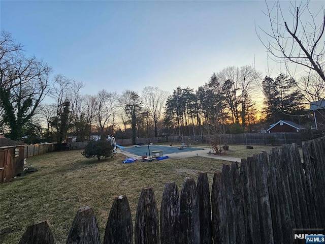 yard at dusk with a fenced backyard