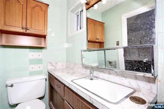 bathroom featuring vanity, tile walls, toilet, and backsplash