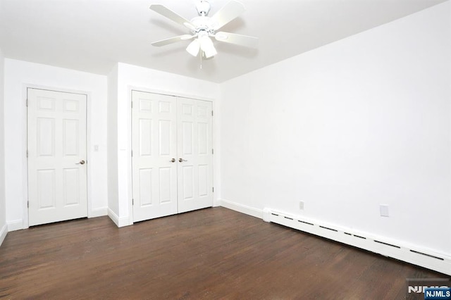 unfurnished bedroom with a closet, dark wood-type flooring, baseboards, and a baseboard radiator