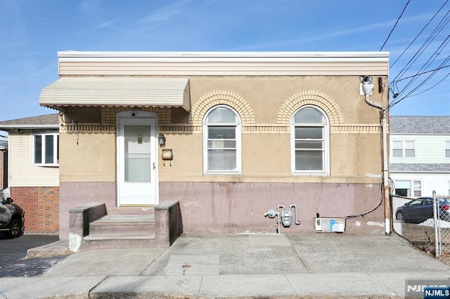 view of front of property featuring fence and stucco siding