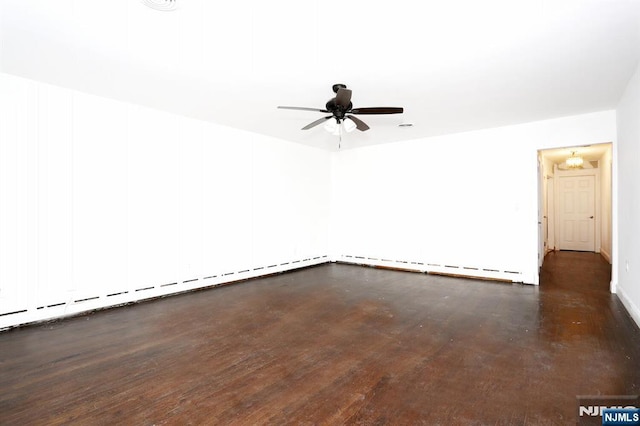 empty room with ceiling fan, baseboard heating, and wood finished floors