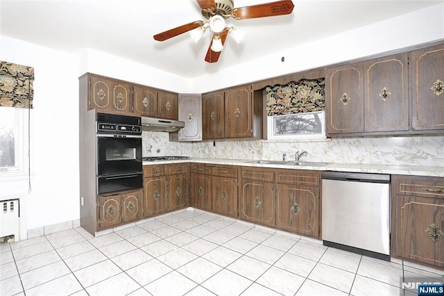 kitchen featuring backsplash, under cabinet range hood, appliances with stainless steel finishes, a warming drawer, and a sink