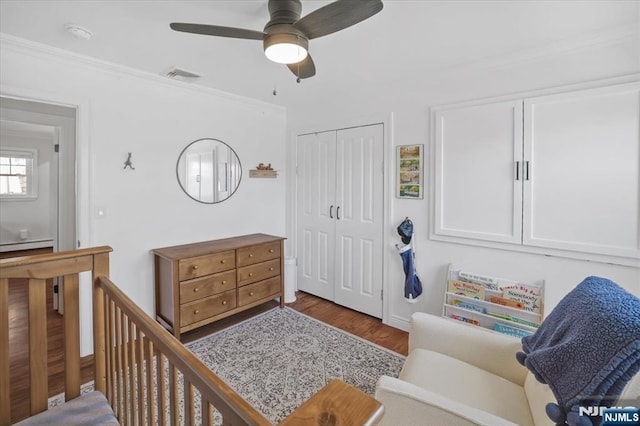 bedroom featuring visible vents, ceiling fan, ornamental molding, wood finished floors, and a closet