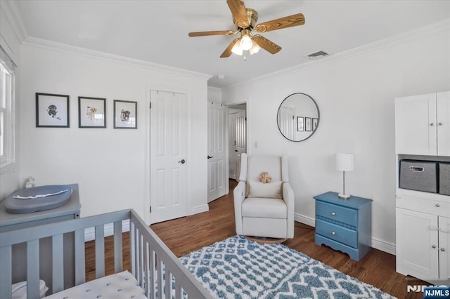 bedroom with visible vents, crown molding, dark wood-type flooring, and baseboards