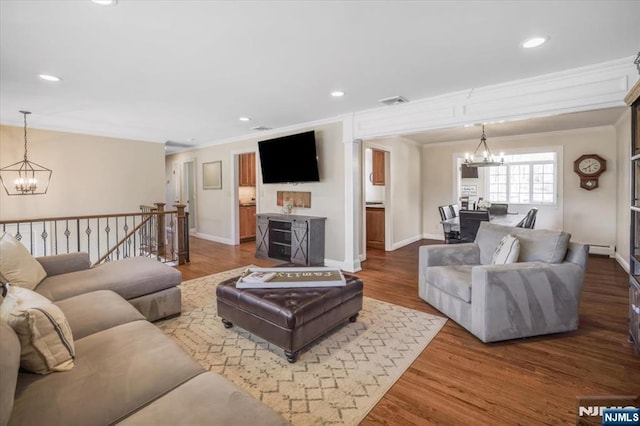 living area featuring recessed lighting, wood finished floors, a chandelier, and ornamental molding