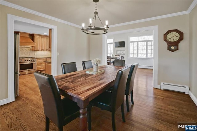 dining space with a chandelier, baseboard heating, crown molding, and wood finished floors