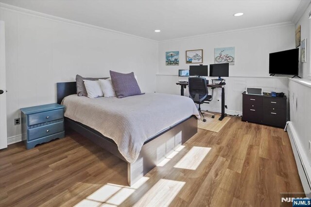 bedroom with light wood-type flooring, a baseboard radiator, ornamental molding, and recessed lighting