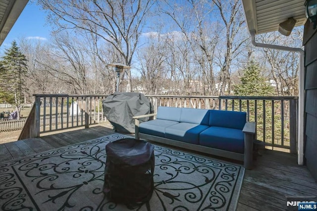 wooden deck with an outdoor living space and a grill