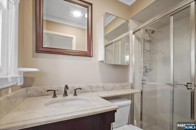 bathroom with toilet, a stall shower, and vanity