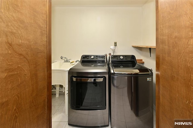 washroom with laundry area, light tile patterned flooring, and separate washer and dryer