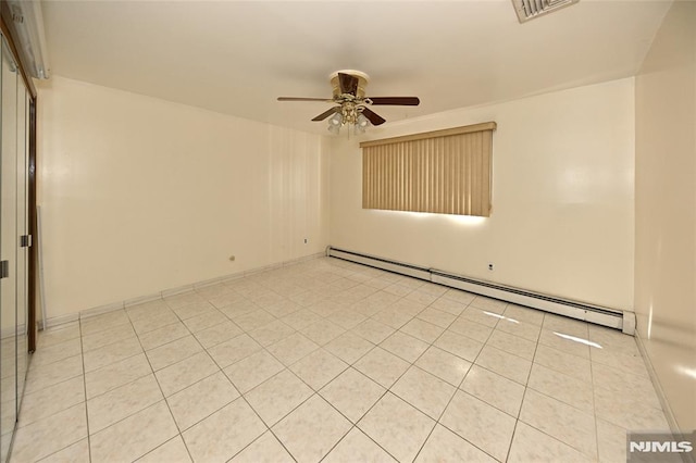 spare room featuring light tile patterned flooring, visible vents, ceiling fan, and a baseboard radiator