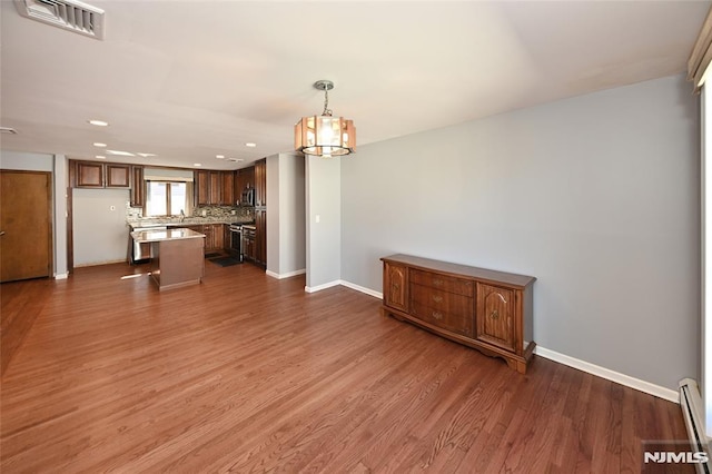 unfurnished living room with recessed lighting, visible vents, baseboards, and dark wood-style floors