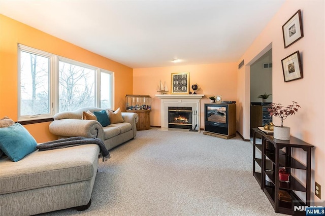 carpeted living room with visible vents and a tile fireplace