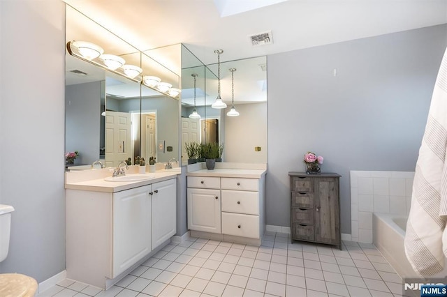 bathroom with visible vents, a tub to relax in, vanity, and tile patterned flooring