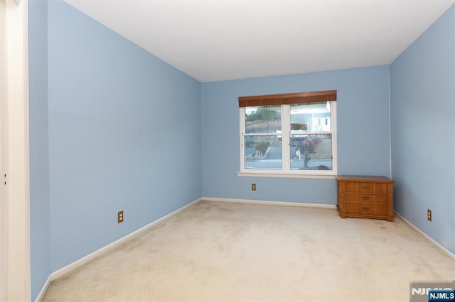 carpeted empty room with baseboards