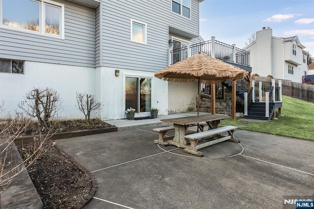 rear view of house with fence, outdoor dining area, stucco siding, a patio area, and a lawn