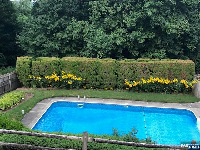 view of swimming pool with a fenced in pool and fence