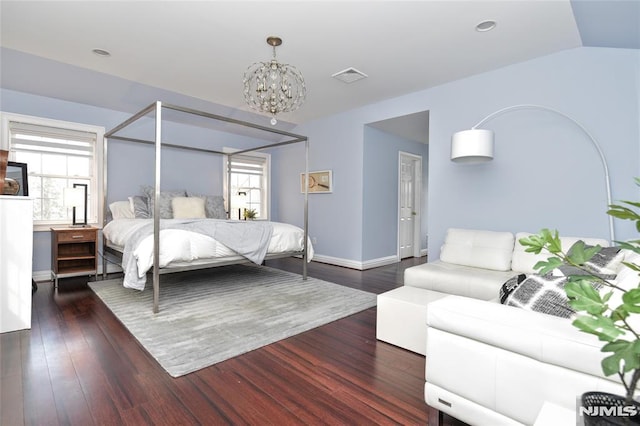 bedroom with a chandelier, visible vents, multiple windows, and wood finished floors