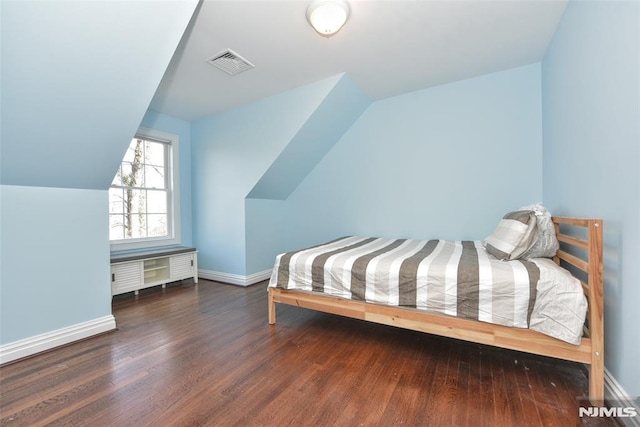 bedroom featuring lofted ceiling, wood finished floors, visible vents, and baseboards