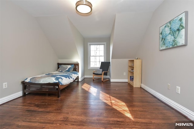 bedroom featuring baseboards, lofted ceiling, and wood finished floors