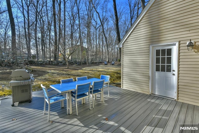 wooden deck featuring outdoor dining space and area for grilling