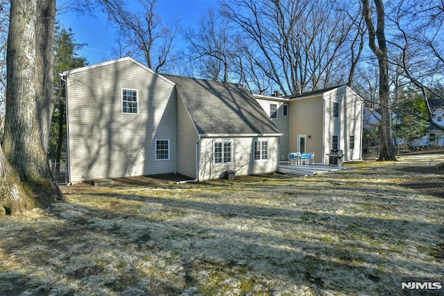 back of house featuring a wooden deck and a shingled roof