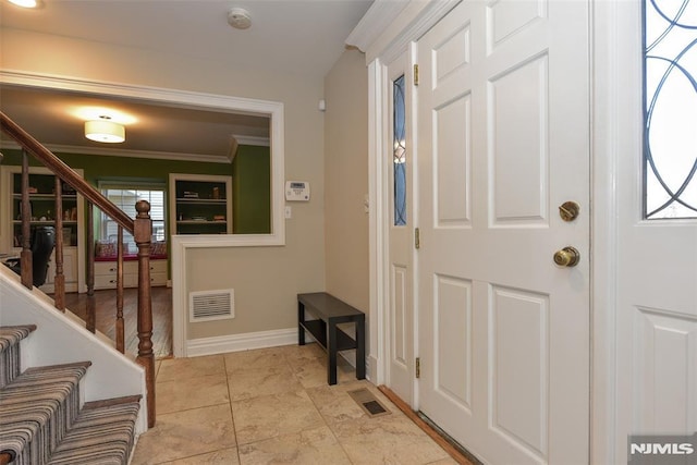 foyer with visible vents, baseboards, stairs, and crown molding