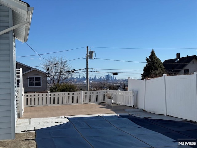 view of swimming pool featuring a patio and fence