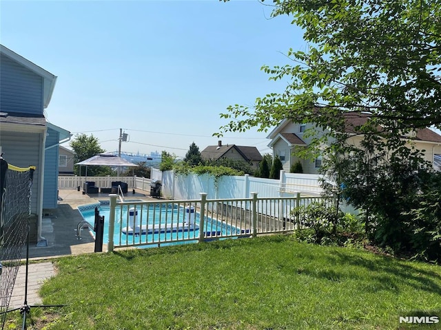 view of pool with a patio area, a fenced backyard, a fenced in pool, and a yard