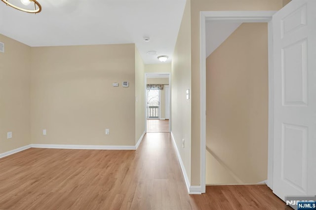 hallway with light wood-style flooring and baseboards