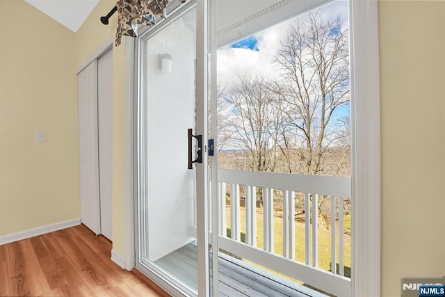 doorway to outside with wood finished floors and baseboards