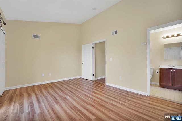 unfurnished bedroom with visible vents, light wood-style flooring, and baseboards