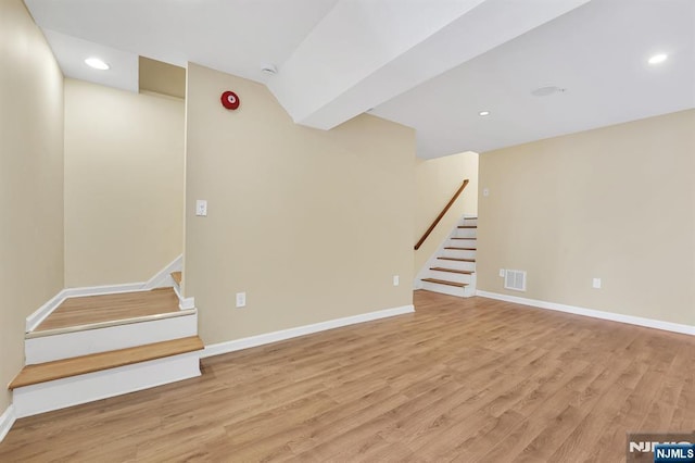 basement featuring stairs, light wood-style flooring, baseboards, and visible vents