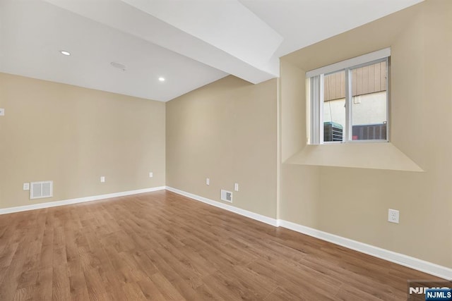 empty room with recessed lighting, visible vents, baseboards, and wood finished floors