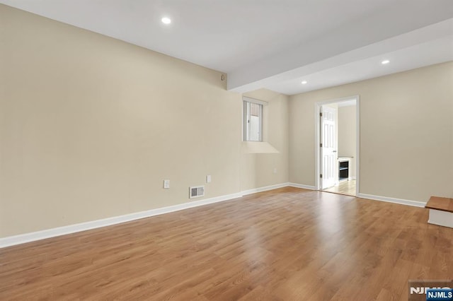 empty room featuring light wood finished floors, visible vents, recessed lighting, and baseboards