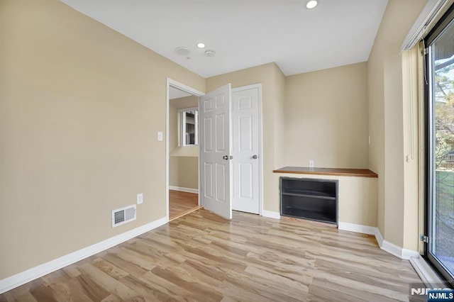 interior space with recessed lighting, wood finished floors, visible vents, and baseboards