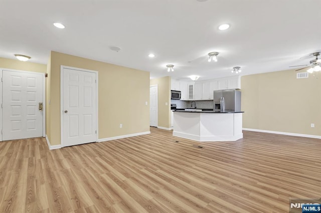 kitchen with visible vents, dark countertops, open floor plan, stainless steel appliances, and white cabinets