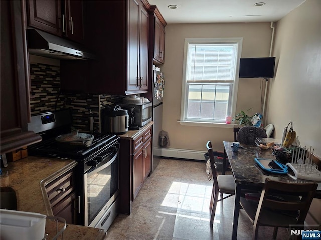 kitchen featuring backsplash, baseboards, under cabinet range hood, baseboard heating, and appliances with stainless steel finishes