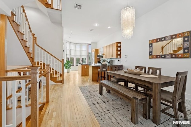 dining space featuring visible vents, stairway, light wood-style flooring, recessed lighting, and a notable chandelier