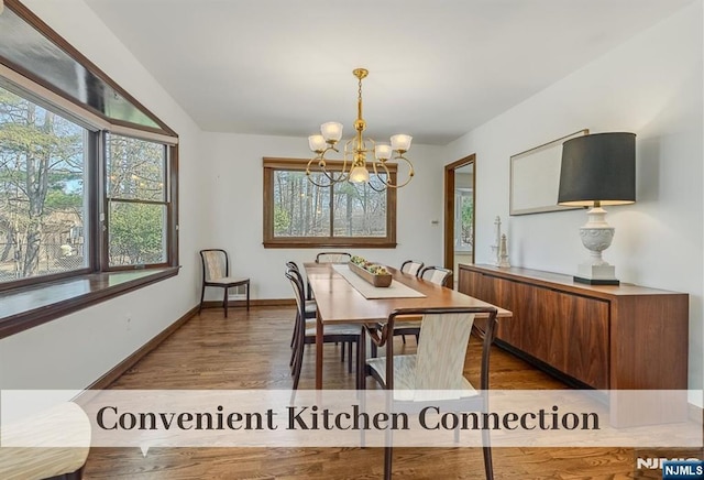 dining room with baseboards, a notable chandelier, and wood finished floors